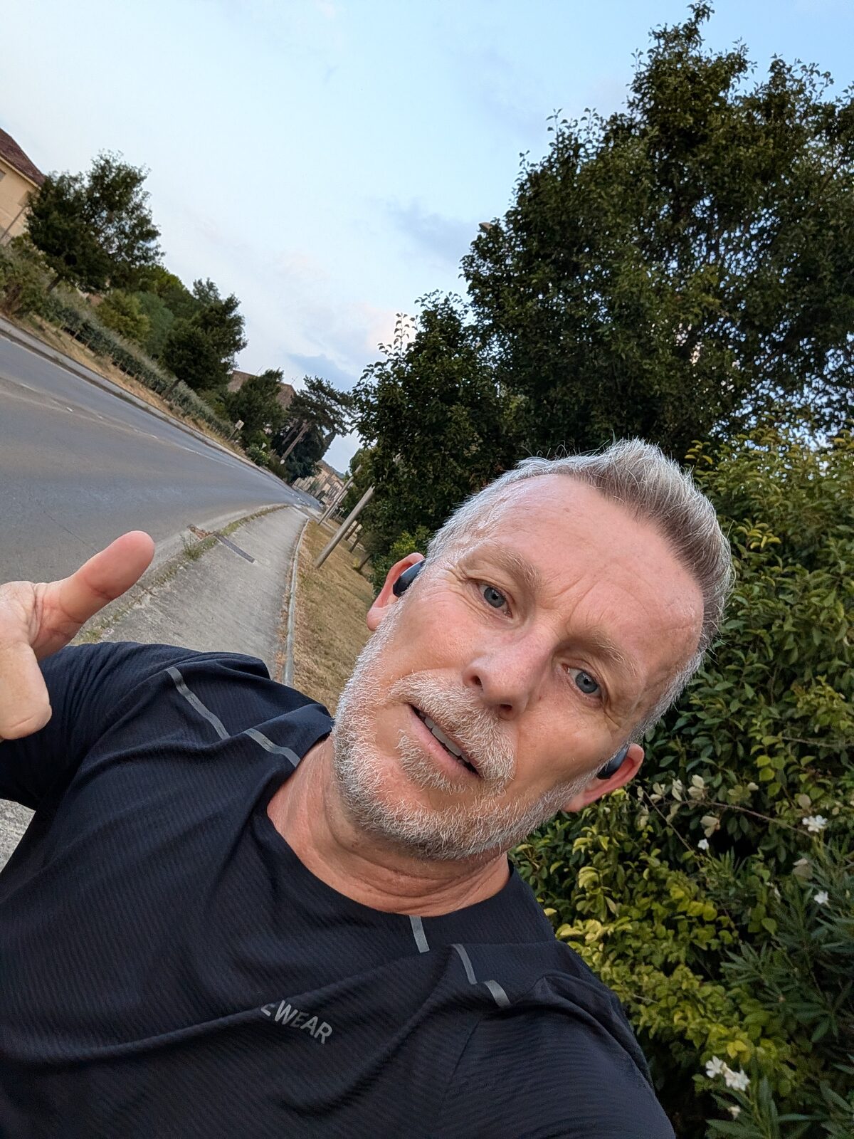 Selfie en pleine sortie au petit matin, route déserte et haie fleurie derrière